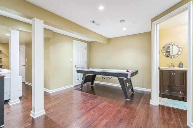 game room featuring wood finished floors, ornate columns, baseboards, and recessed lighting