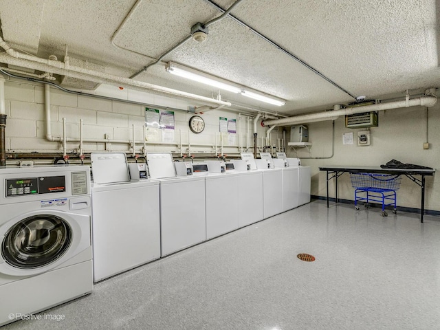 community laundry room featuring washing machine and clothes dryer and baseboards