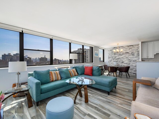 living room with a chandelier, light wood-type flooring, and a skyline view