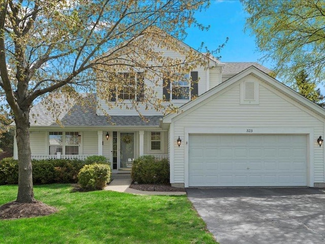 323 Deerpath Ct, Wauconda, IL 60084 - traditional home with concrete driveway, a garage, a front yard, a porch, and a shingled roof