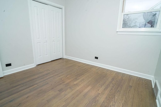 9539 S Forest Ave, Chicago, IL 60628 - unfurnished bedroom featuring baseboards, wood finished floors, and a closet
