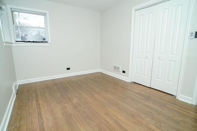9539 S Forest Ave, Chicago, IL 60628 - unfurnished bedroom with wood finished floors, baseboards, and a closet