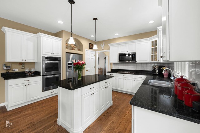 2708 Chittenden Ct, Naperville, IL 60564 - kitchen featuring stainless steel appliances, a sink, dark wood-style floors, a center island, and white cabinetry