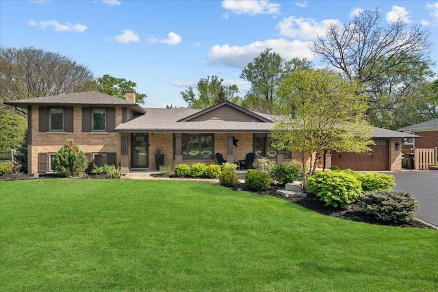 208 N Pkwy, Prospect Heights, IL 60070 - split level home with driveway, a front lawn, brick siding, a chimney, and an attached garage