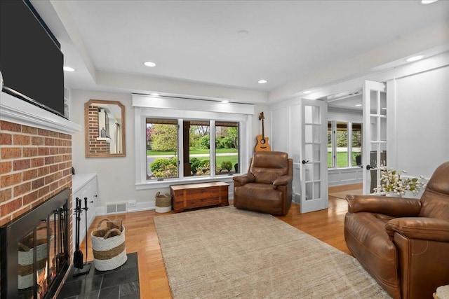 208 N Pkwy, Prospect Heights, IL 60070 - sitting room featuring a brick fireplace, baseboards, recessed lighting, wood finished floors, and french doors