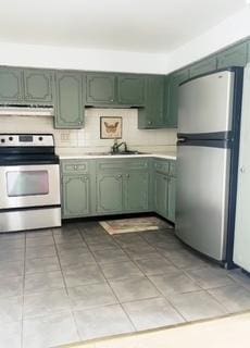 135 S Kenilworth Ave Unit 8, Oak Park, IL 60302 - kitchen featuring green cabinetry, appliances with stainless steel finishes, light countertops, range hood, and light tile patterned floors