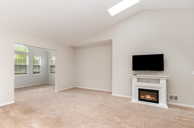 21508 Lake St Clair Dr Unit 0, Crest Hill, IL 60403 - unfurnished living room with carpet, lofted ceiling, a skylight, a glass covered fireplace, and baseboards