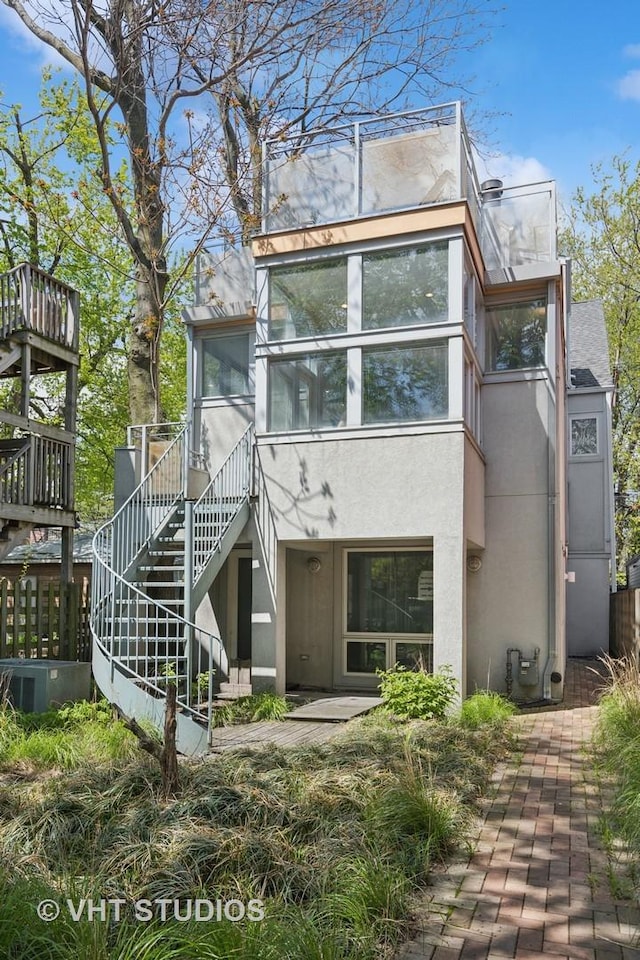 1534 W Henderson St, Chicago, IL 60657 - back of house with stucco siding, stairway, and a sunroom