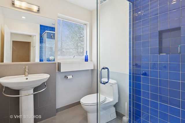 1534 W Henderson St, Chicago, IL 60657 - full bathroom featuring a stall shower, tile patterned floors, toilet, tile walls, and a sink