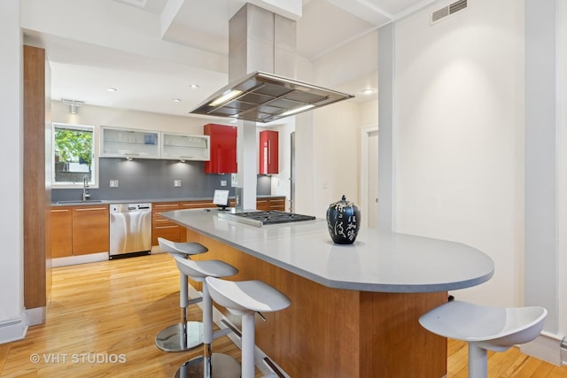 1534 W Henderson St, Chicago, IL 60657 - kitchen featuring stainless steel appliances, island exhaust hood, a kitchen bar, and light wood-style flooring