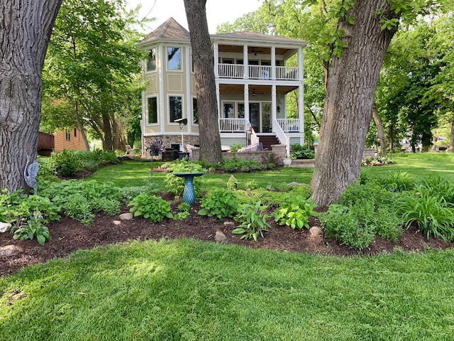 75 N Lake Ave, Third Lake, IL 60030 - view of front of property featuring a balcony, a front yard, ceiling fan, a porch, and stone siding