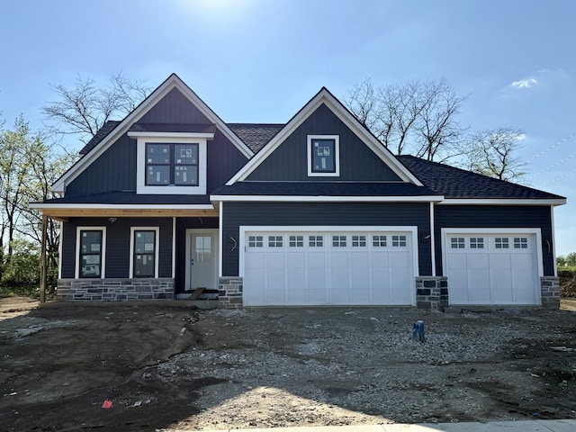 1117 Briarwood Ln, Mahomet, IL 61853 - view of front of property featuring stone siding, a porch, roof with shingles, asphalt driveway, and an attached garage