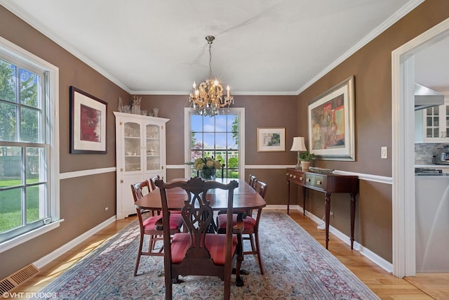 816 S Hamlin Ave, Park Ridge, IL 60068 - dining room with healthy amount of natural light, a chandelier, light wood finished floors, and crown molding