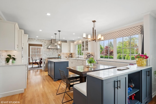 816 S Hamlin Ave, Park Ridge, IL 60068 - kitchen featuring a sink, white cabinetry, wall chimney range hood, a kitchen island, and decorative backsplash