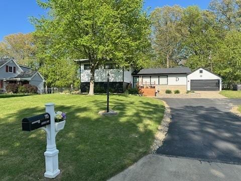 1415 Woodridge Dr, Danville, IL 61832 - view of front of home with a front yard, an outbuilding, a detached garage, and asphalt driveway