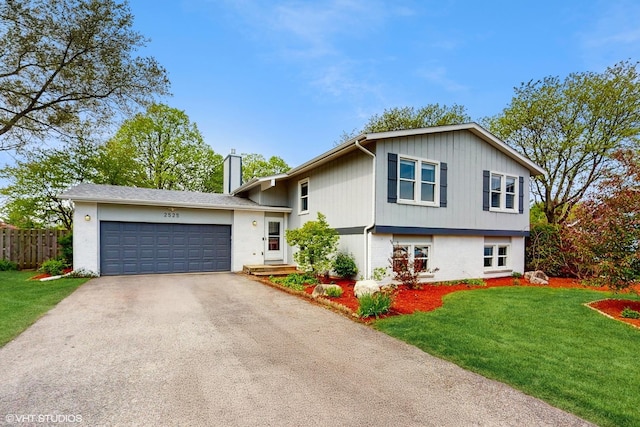 2525 Ridge Rd, Aurora, IL 60504 - tri-level home featuring driveway, a garage, and a chimney