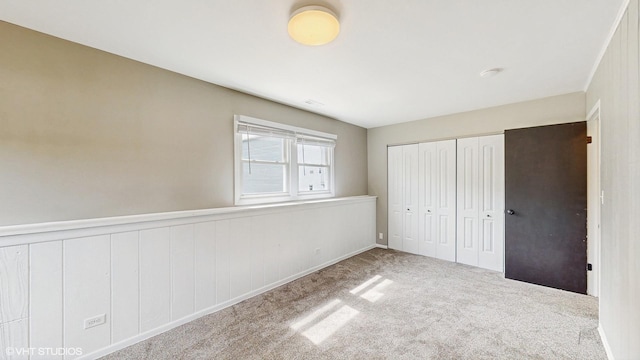 2525 Ridge Rd, Aurora, IL 60504 - unfurnished bedroom with a wainscoted wall, a closet, and carpet