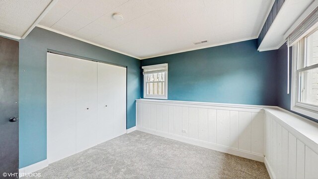 2525 Ridge Rd, Aurora, IL 60504 - unfurnished bedroom featuring carpet flooring, a wainscoted wall, ornamental molding, and a closet