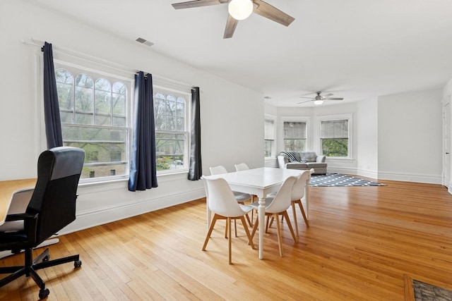 dining area featuring a ceiling fan, plenty of natural light, and light wood-style floors