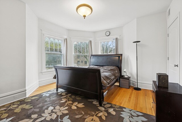 bedroom with wood finished floors and baseboards