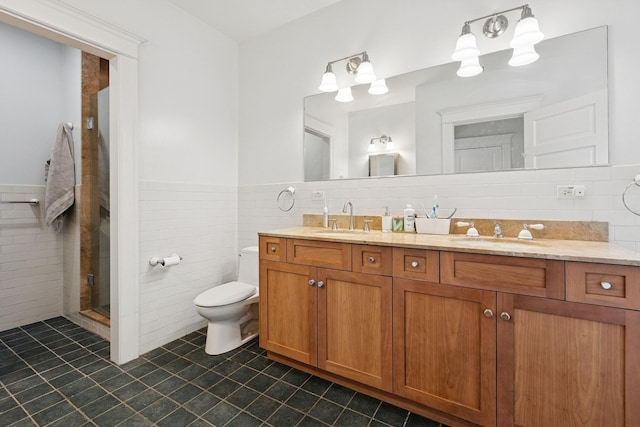 full bathroom with tile walls, tile patterned flooring, wainscoting, toilet, and a stall shower