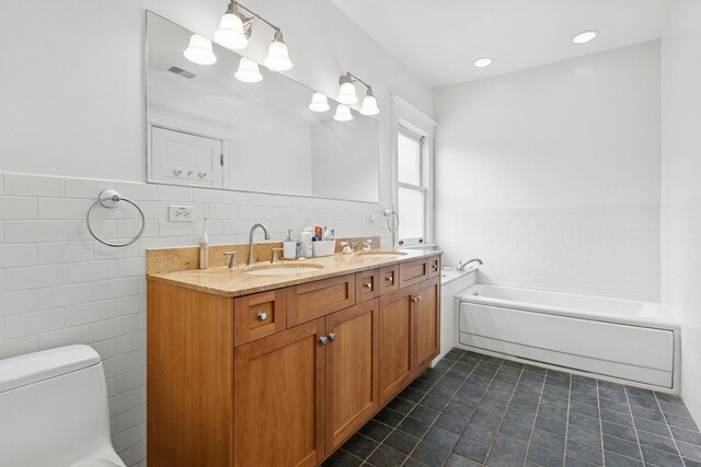 full bathroom featuring tile walls, tile patterned floors, toilet, a garden tub, and double vanity