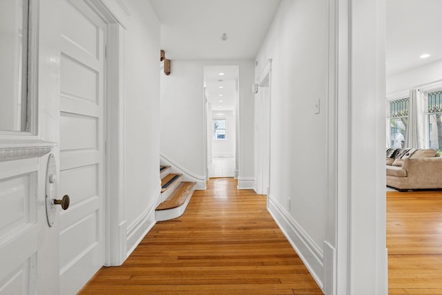 hall with light wood-style flooring, recessed lighting, and baseboards