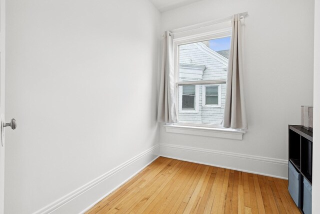 unfurnished room featuring baseboards and light wood-type flooring