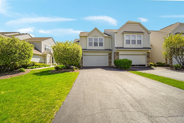 townhome / multi-family property with driveway, a garage, a front lawn, and brick siding