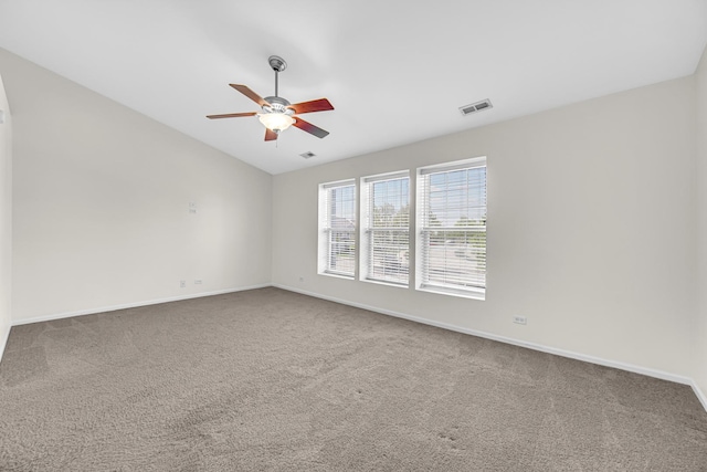 spare room with ceiling fan, carpet, baseboards, and vaulted ceiling
