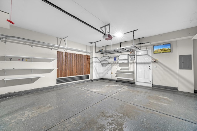 garage featuring a garage door opener, electric panel, and baseboards