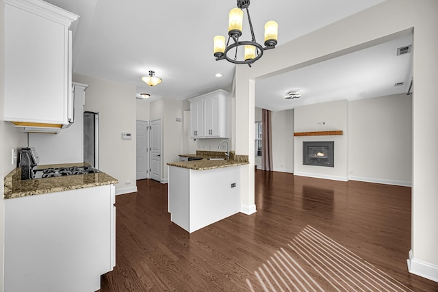 kitchen with gas range oven, white cabinetry, dark wood-type flooring, and recessed lighting