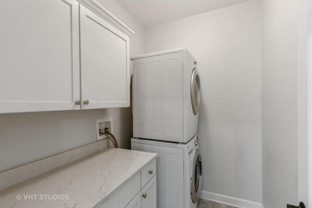 921 Eineke Blvd, Algonquin, IL 60102 - laundry area featuring stacked washing machine and dryer, cabinet space, and baseboards