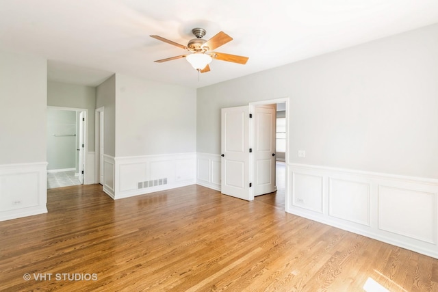 921 Eineke Blvd, Algonquin, IL 60102 - unfurnished room featuring ceiling fan, light wood-type flooring, a wainscoted wall, and a decorative wall