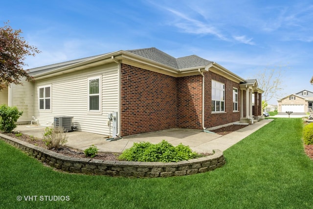 921 Eineke Blvd, Algonquin, IL 60102 - view of home's exterior with central AC unit, a lawn, a patio, and brick siding