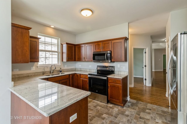921 Eineke Blvd, Algonquin, IL 60102 - kitchen featuring stainless steel appliances, a sink, a peninsula, light stone countertops, and brown cabinets