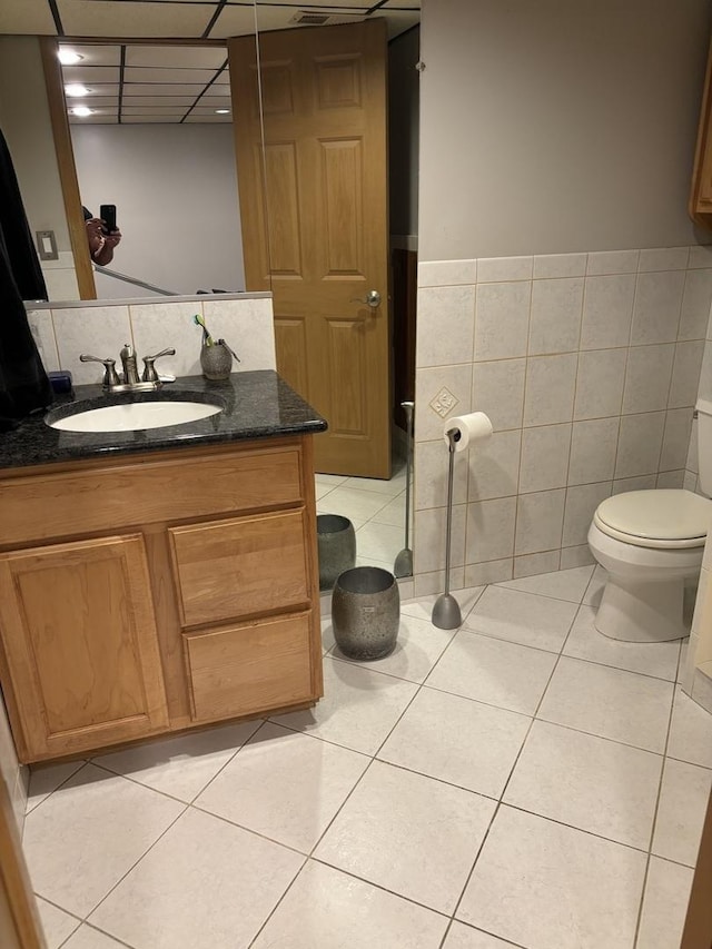3991 Whispering Trails Dr, Hoffman Estates, IL 60192 - half bath with tile patterned floors, toilet, vanity, tile walls, and wainscoting