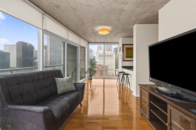 living area with light wood finished floors, floor to ceiling windows, and baseboards