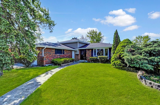 split level home featuring brick siding and a front lawn