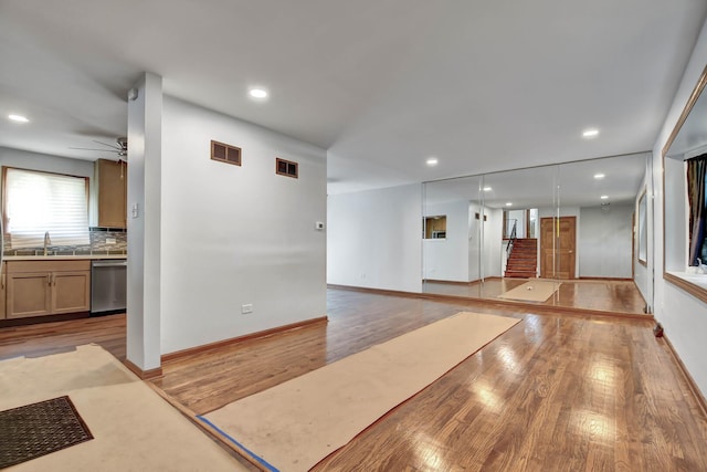 unfurnished room featuring light wood finished floors, a sink, recessed lighting, a ceiling fan, and baseboards