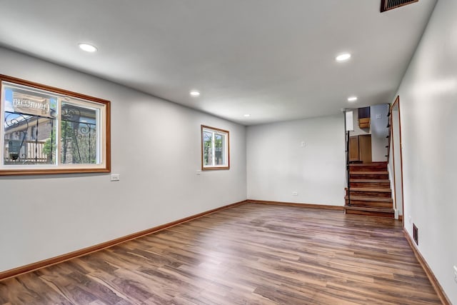 basement featuring wood finished floors, recessed lighting, stairway, and baseboards