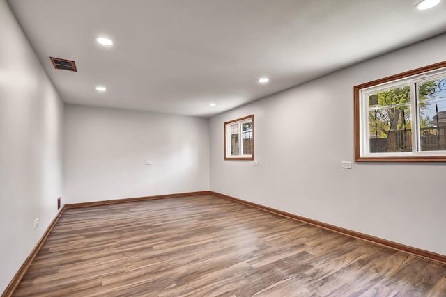 unfurnished room with recessed lighting, wood finished floors, and baseboards