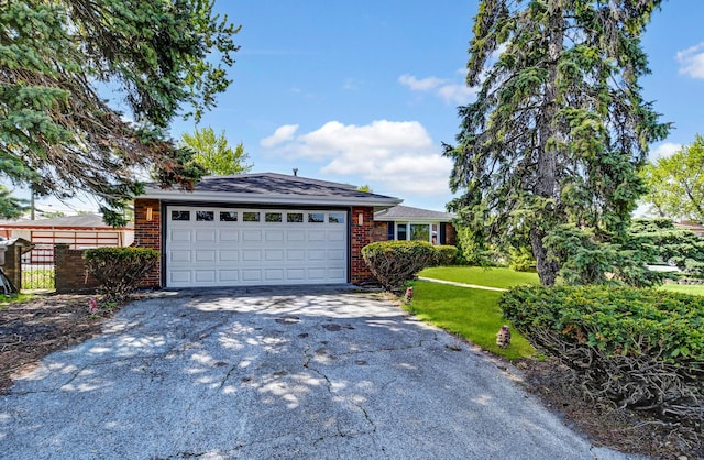 view of front of home featuring driveway, a garage, and brick siding