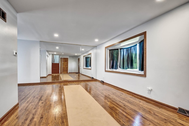 unfurnished room with wood finished floors, baseboards, and recessed lighting