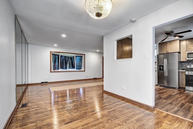 unfurnished living room featuring dark wood finished floors, baseboards, recessed lighting, and a ceiling fan