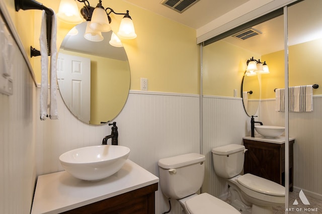 7930 Woodglen Ln Unit 204, Downers Grove, IL 60516 - bathroom featuring a wainscoted wall, toilet, vanity, and a chandelier