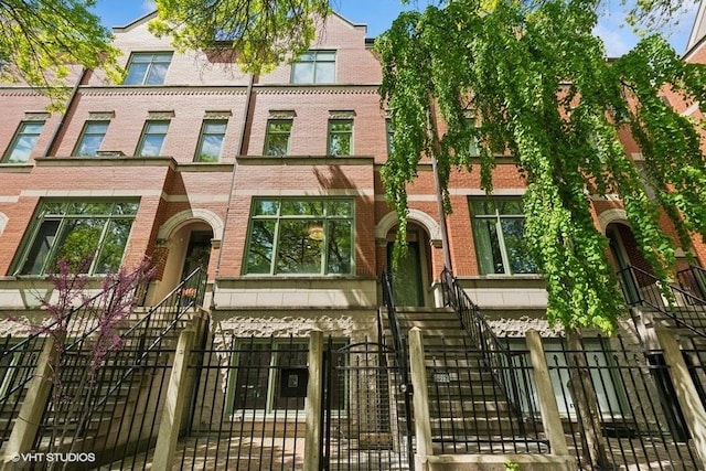 view of front of home featuring brick siding and a fenced front yard
