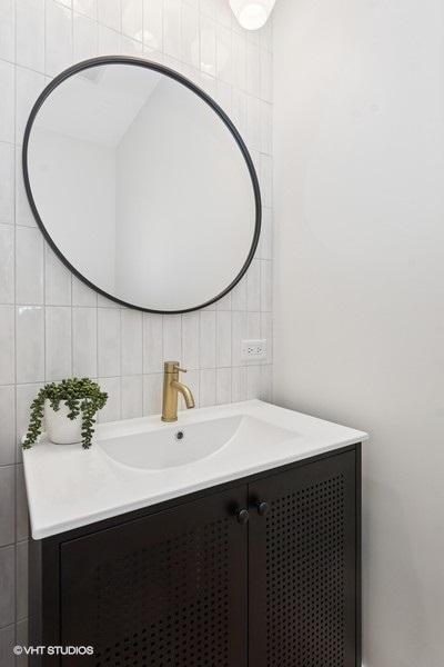 bathroom with tile walls, vanity, and backsplash