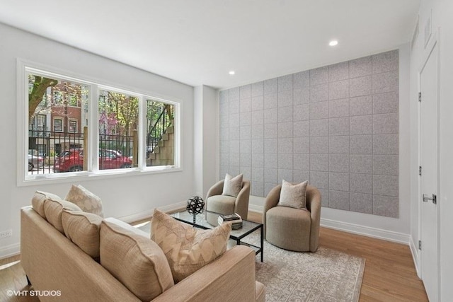 living room with wood finished floors, baseboards, and recessed lighting