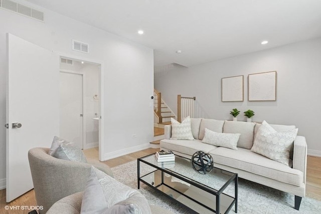 living area with baseboards, light wood-type flooring, and recessed lighting